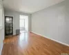 Empty room with radiator, wood finished floors, and baseboards