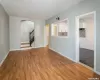 Empty room featuring arched walkways, stairway, baseboards, and wood finished floors