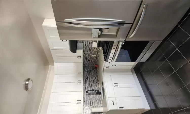 Kitchen featuring a sink, fridge, exhaust hood, decorative backsplash, and stove