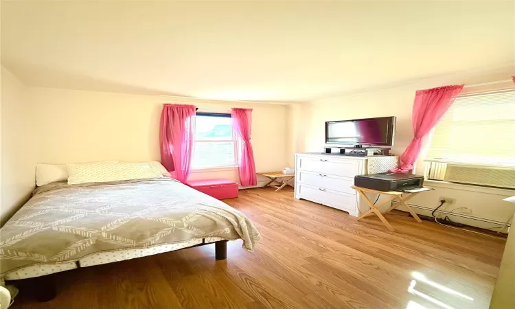 Bedroom featuring baseboard heating and light wood-style flooring