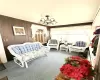 Carpeted living room with a notable chandelier and wood walls