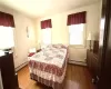 Bedroom featuring wood finished floors and a baseboard radiator