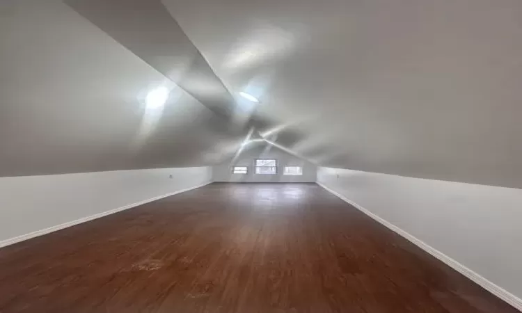 Bonus room featuring vaulted ceiling, wood finished floors, and baseboards