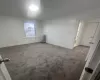 Spare room featuring carpet flooring, radiator, crown molding, and baseboards