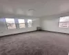 Unfurnished room featuring radiator, baseboards, and dark carpet