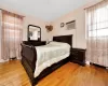 Bedroom with light wood finished floors and a wall unit AC