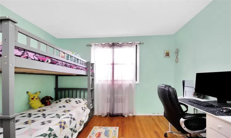 Bedroom featuring radiator and wood finished floors