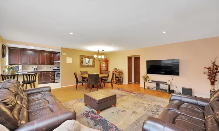 Living area featuring recessed lighting, light wood finished floors, and a chandelier