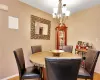 Dining space featuring a notable chandelier, wood finished floors, and baseboards