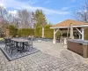 View of patio with a gazebo, a hot tub, and outdoor dining area