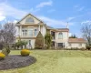 View of front of home featuring a balcony, stucco siding, a chimney, and a front lawn