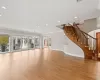 Unfurnished living room featuring wood finished floors, recessed lighting, stairway, arched walkways, and baseboards