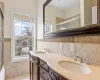 Full bathroom with a sink, tile walls, and a wealth of natural light