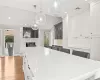 Kitchen featuring a wealth of natural light, visible vents, a fireplace, and wood finished floors