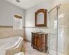 Bathroom featuring visible vents, a stall shower, vanity, and a tub with jets