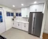 Kitchen with white cabinetry, recessed lighting, high quality fridge, and backsplash