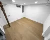 Finished basement featuring electric panel, baseboards, light wood-style flooring, and recessed lighting