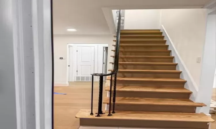 Stairs featuring recessed lighting, visible vents, baseboards, and wood finished floors