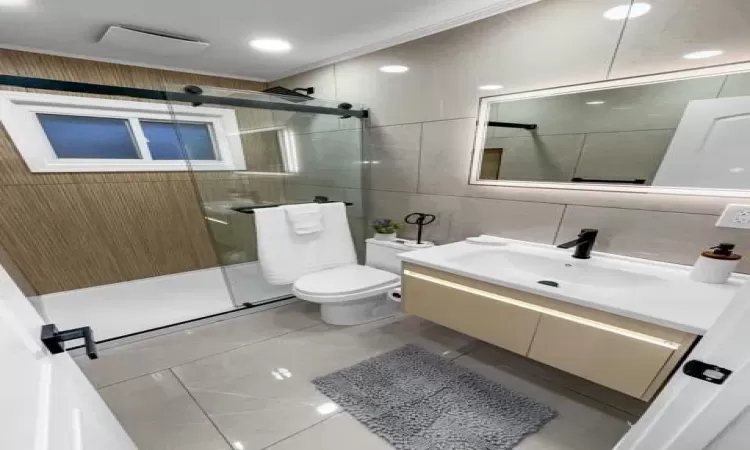 Full bathroom featuring toilet, tasteful backsplash, tile walls, a shower stall, and vanity