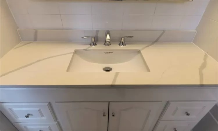 Bathroom featuring decorative backsplash and vanity