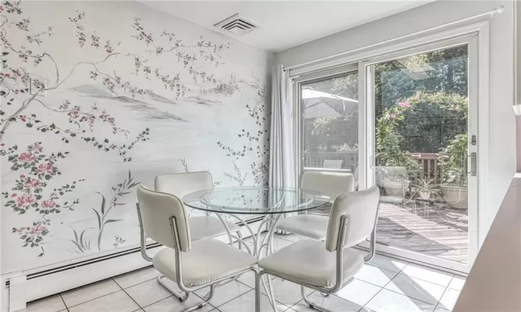 Dining space featuring visible vents, baseboard heating, and light tile patterned flooring