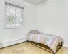 Bedroom featuring a baseboard radiator and wood finished floors