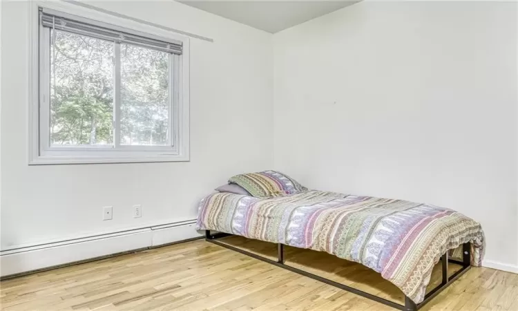 Bedroom featuring a baseboard radiator and wood finished floors