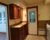 Kitchen with baseboard heating, radiator heating unit, gas range gas stove, and a wainscoted wall