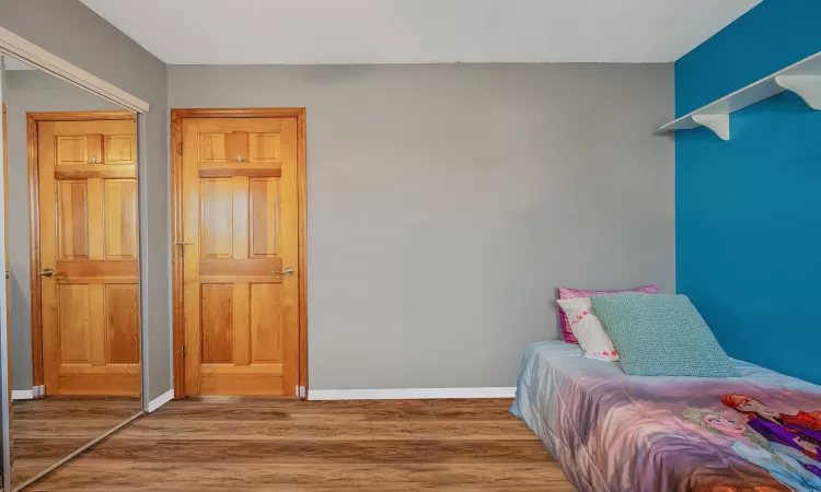 Bedroom featuring baseboards and wood finished floors