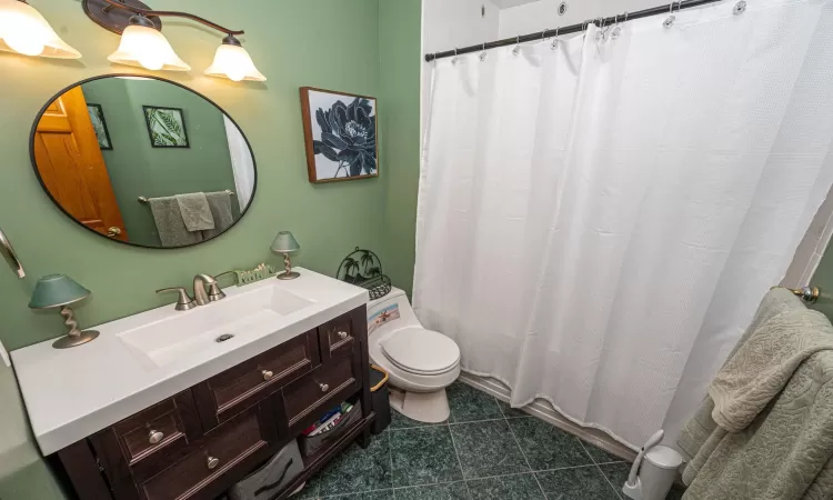 Bathroom featuring vanity, tile patterned floors, toilet, and a shower with shower curtain