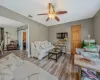 Living area featuring a ceiling fan, a barn door, wood finished floors, and visible vents