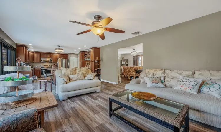 Living room featuring visible vents, wood finished floors, recessed lighting, baseboards, and ceiling fan