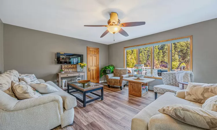 Living room with ceiling fan and light wood-style floors