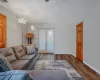 Living room with baseboards, an inviting chandelier, and wood finished floors