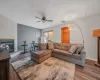 Living room featuring a glass covered fireplace, light wood-style flooring, and baseboards