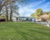 Ranch-style house featuring a swimming pool, fence, a front yard, a chimney, and a patio area