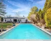 Pool with a wooden deck and a yard