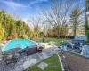 Outdoor pool with a patio, a lawn, and a hot tub