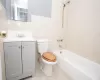 Full bath with tile patterned flooring, washtub / shower combination, toilet, vanity, and tile walls