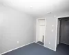 Unfurnished bedroom featuring a closet, visible vents, baseboards, and dark colored carpet