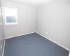 Carpeted empty room featuring baseboards