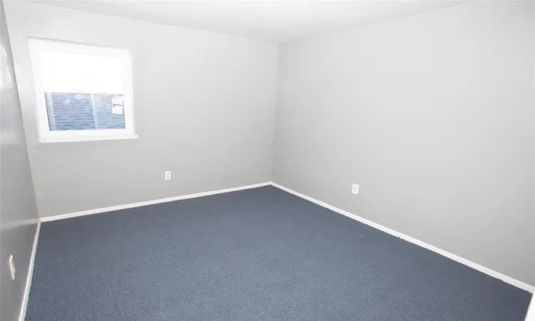 Carpeted empty room featuring baseboards