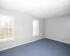 Empty room featuring visible vents, carpet, and baseboards