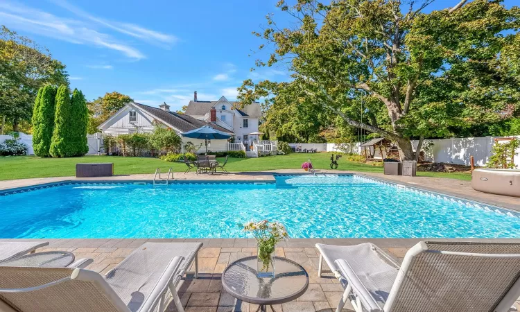 View of swimming pool with a yard, a fenced in pool, and a fenced backyard