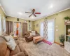 Carpeted living room with a ceiling fan, baseboards, a wall mounted AC, ornamental molding, and a textured ceiling