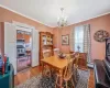 Dining space with light wood-type flooring, baseboard heating, a chandelier, and crown molding