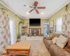 Carpeted living area featuring ceiling fan, a textured ceiling, crown molding, and a wood stove