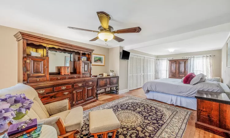 Bedroom featuring light wood-type flooring, baseboards, a closet, and ceiling fan