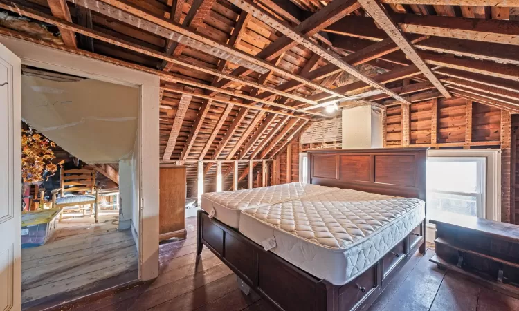 Bedroom with lofted ceiling and dark wood-style flooring