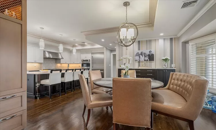 Dining space with visible vents, recessed lighting, crown molding, and dark wood-type flooring